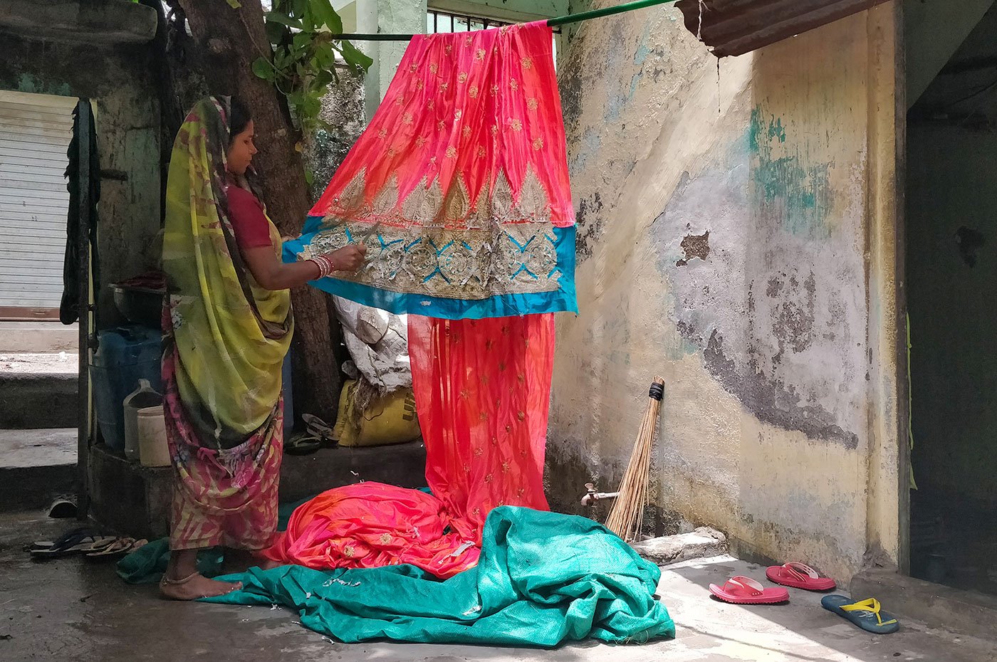 Renuka Pradhan’s one-room home in the Mina Nagar area of north Surat turns into her working space every morning. She cuts threads out of more than 75 saris every day. The constant work has led to cuts and bruises on her fingers