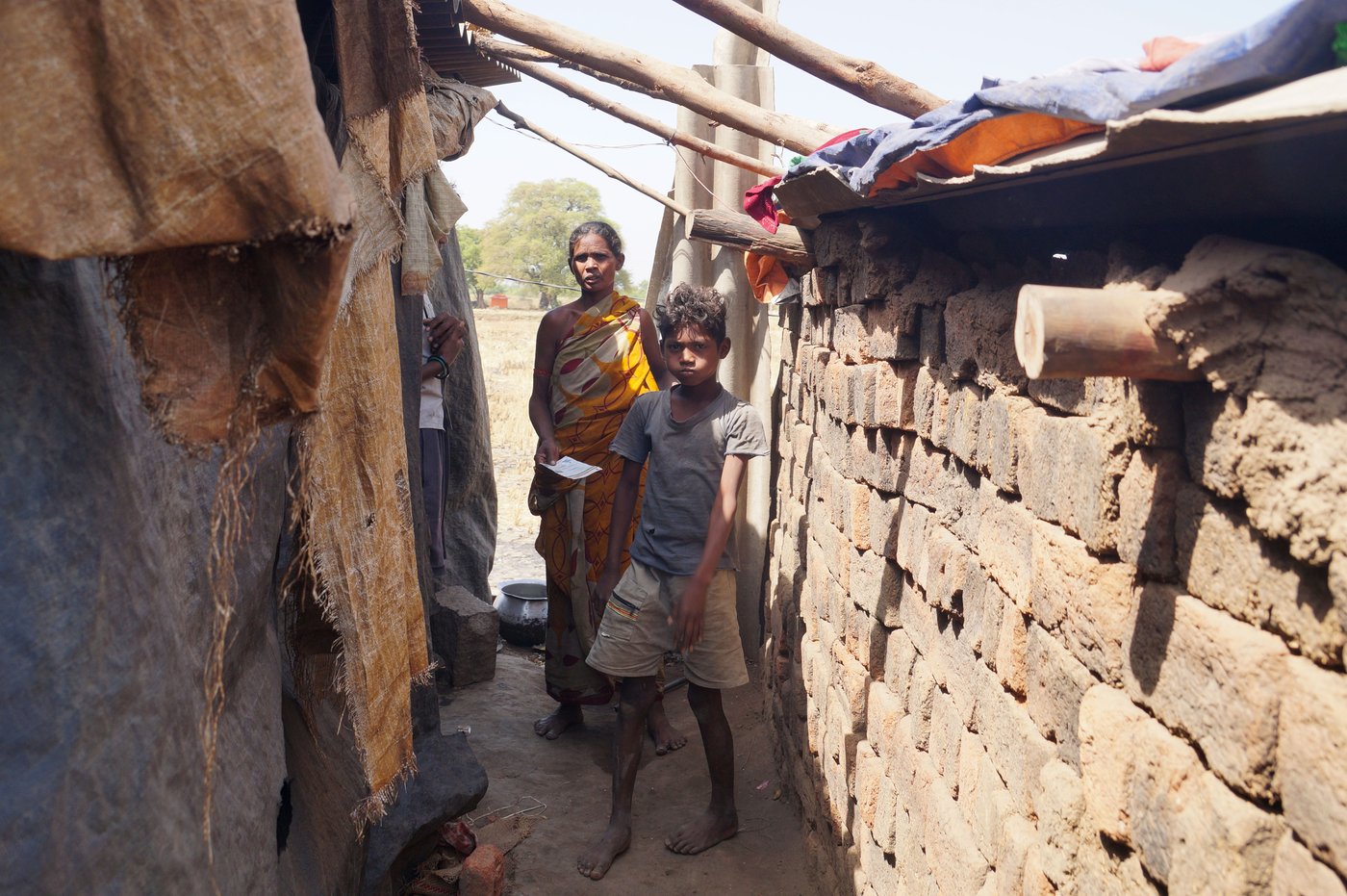 Left: Kuni Tamalia and son Jagannadh near their small home made with loosely stacked bricks. Right: Sumitra Pradhan, Gopal Raut and daughter Rinki