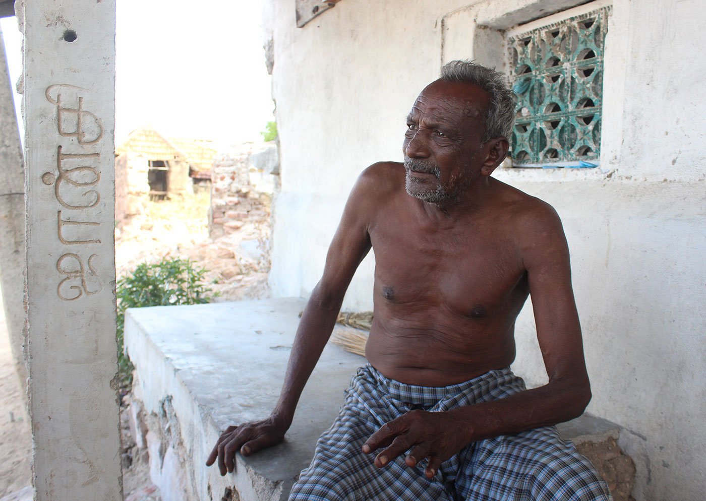 Kandasamy seated on the porch of his house