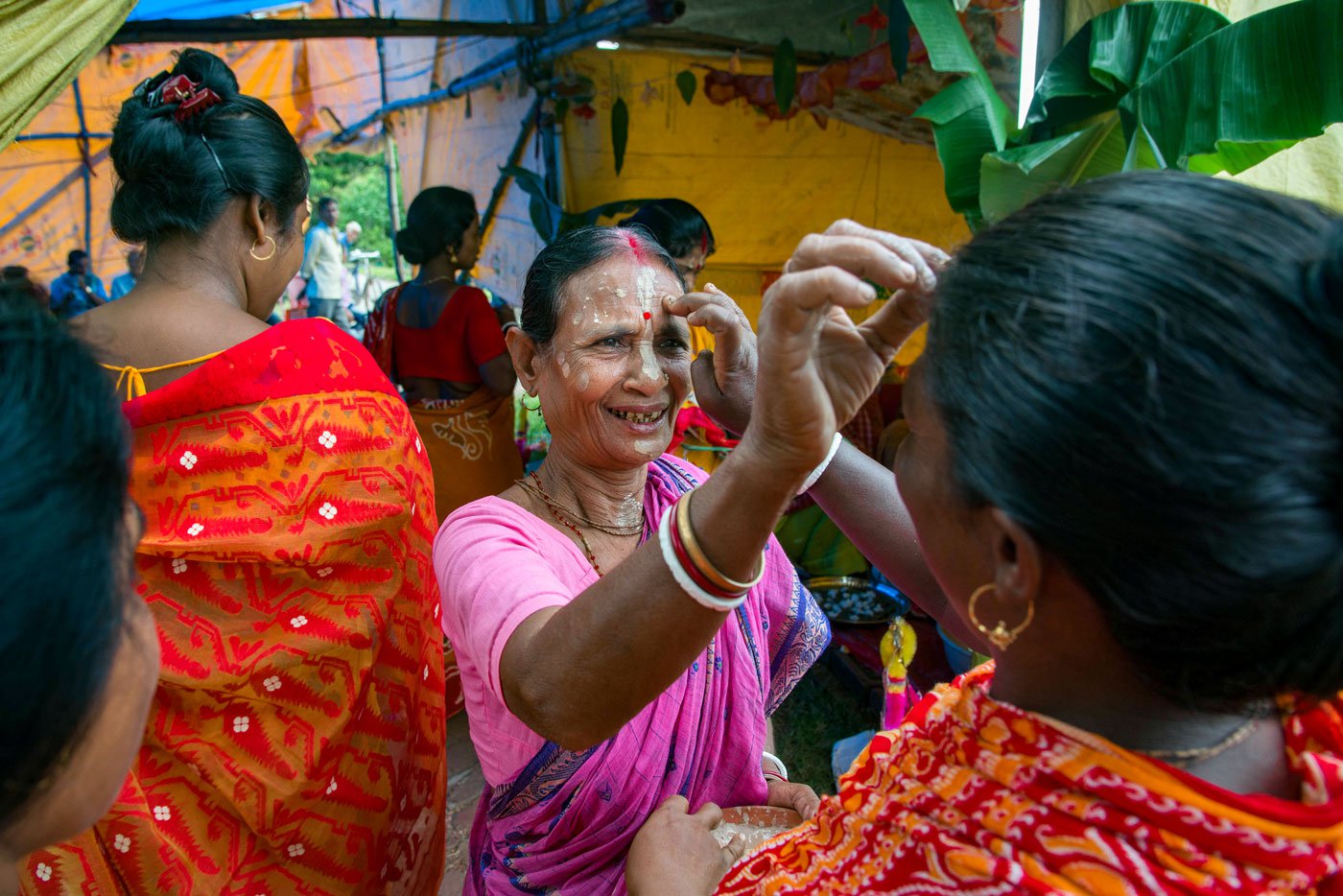 Left: Snake goddess Manasa is a popular among the Dalits of South 24 Paraganas as well as Bankura, Birbhum, and Purulia districts. On the day of Viswakarma Puja (September 17 this year) many households in remote villages in the Indian expanse of the Sundarbans worship the snake goddess and perform pala gaan. Right: Older women in Rajat Jubilee village welcome others in the community to the Puja.