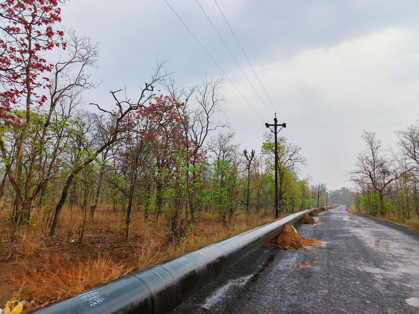 Huge pipelines (left) are being laid to take water from a lake to the Surjagarh mines even as large trucks (right) ferry the iron ore out of the district to steel plants elsewhere