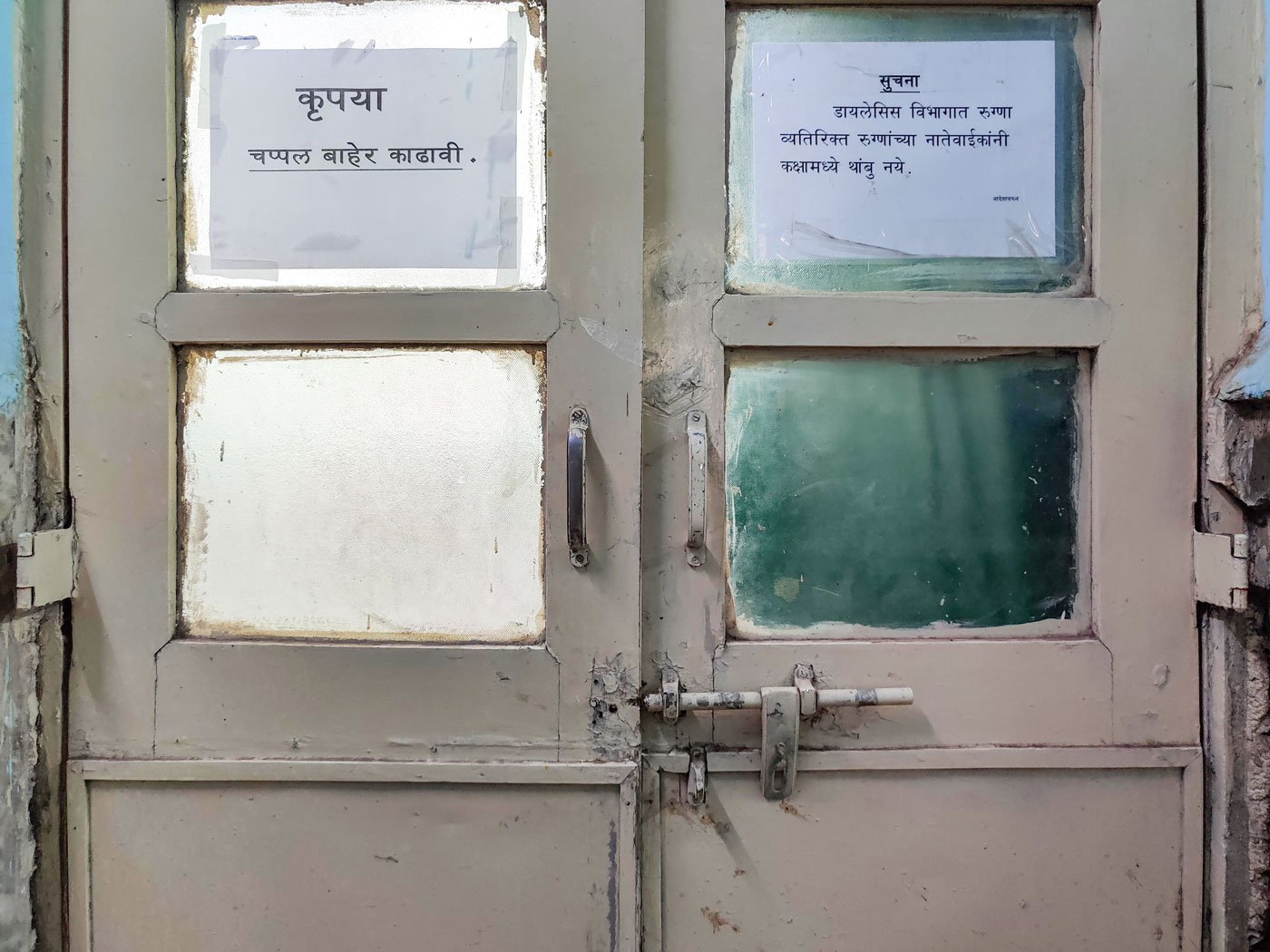 The door to the dialysis room prohibits anyone other than the patient inside so Dnyaneshwar (right) must wait outside for Archana to finish her procedure