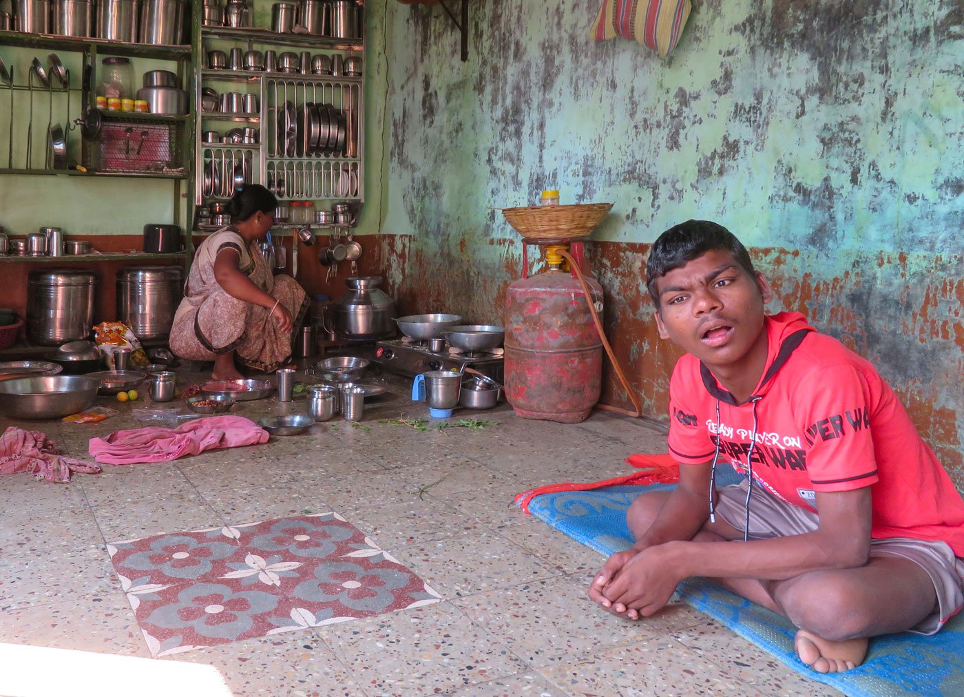 Vaibhav Petkar and his mother, Sulakshana, who is seen cooking in the kitchen of their one-room house