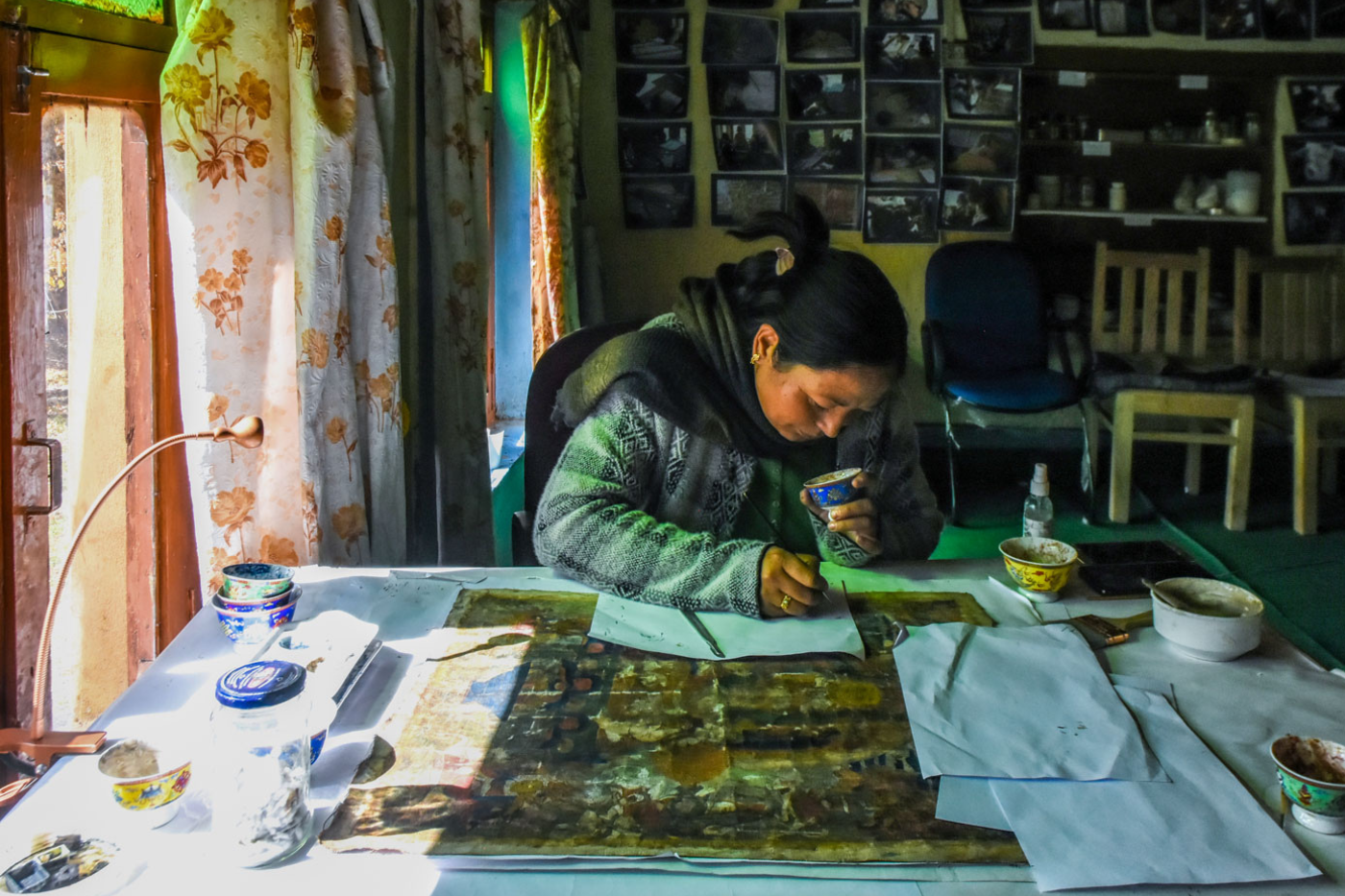 Left: One of the first members of Himalayan Art Preservers (HAP), Tsering Spaldon, restoring a 17th century old Thangka painting.