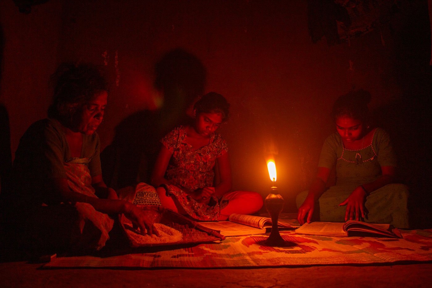 Right : The soft glow of the kerosene lamp helps my sister Kumari and my niece Ramya study, while our amma makes rice