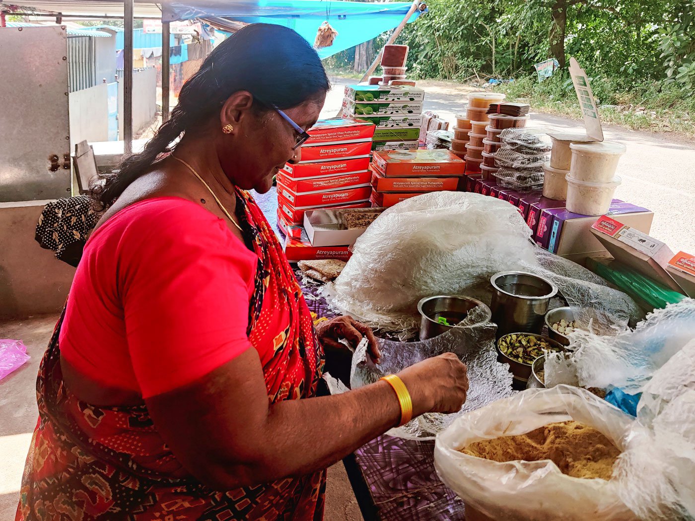 Shyamala folds a film of rice paper with dry fruits, jaggery powder and more to make a poothareku . First she gently flattens the film, spreads a few drops of sugar syrup and a then generous amount of ghee after which she adds dry fruits