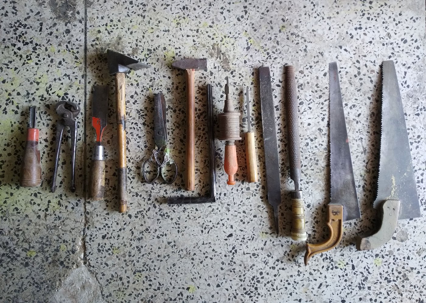 The tools of the craft from left to right: nola , jamura (plier), chorsi (chisel), bhasola (chipping hammer), scissors, hammer, three hole cleaners, two rettis ( flat and round hand files) and two aaris (hand saws)