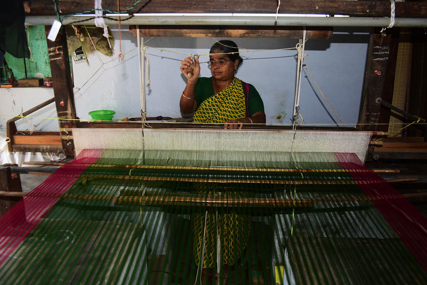 Jayakantha Veerabathiran, 45, weaves a plain saree that will later be embellished with embroidery. In most homes, the looms are placed on the floor with a shallow pit for the pedals