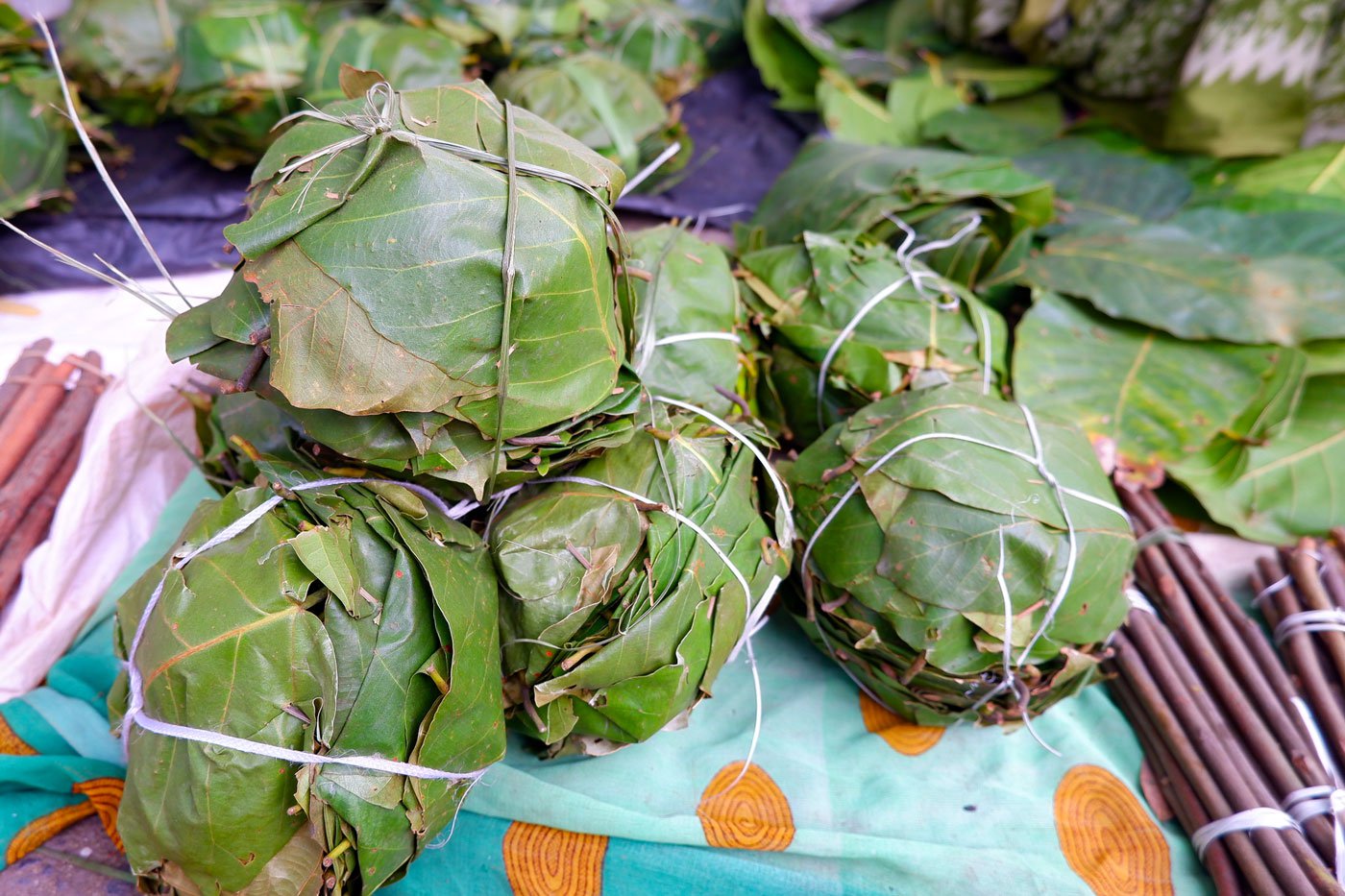 Left: Four to six leaves are arranged one upon the other and sewn together with strips of bamboo to make the dona . They fold the edges to create a circular shape so that when food is served, it won’t fall out. A bundle of 12 donas sells for four rupees.