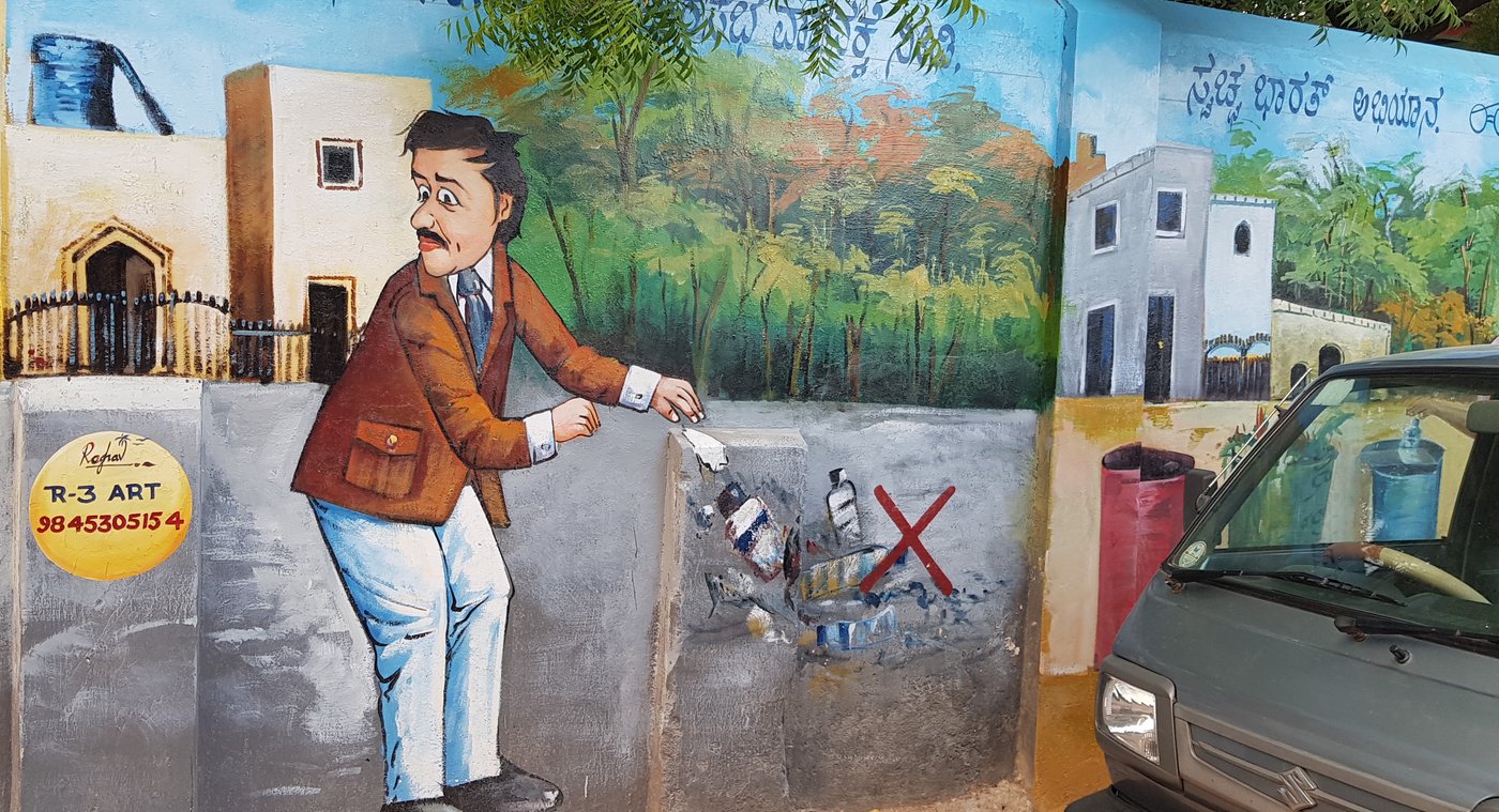 painting on the wall of a man throwing garbage