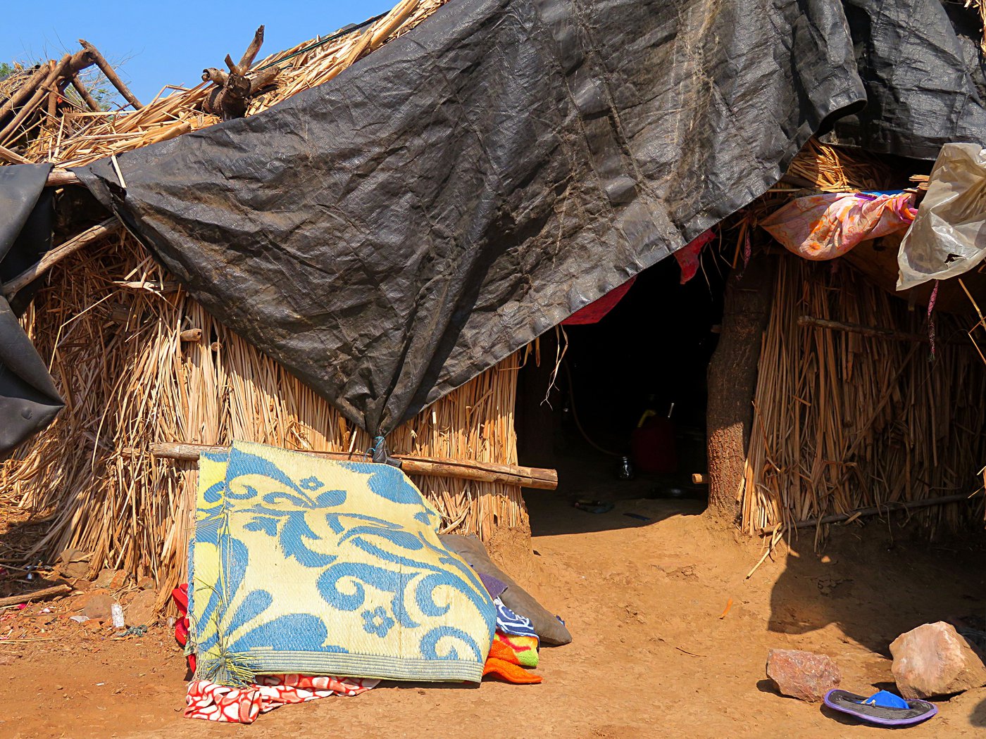 With Amol in 'isolation', his mother Sunita (left) and siblings remained in their own small hut nearby (right)