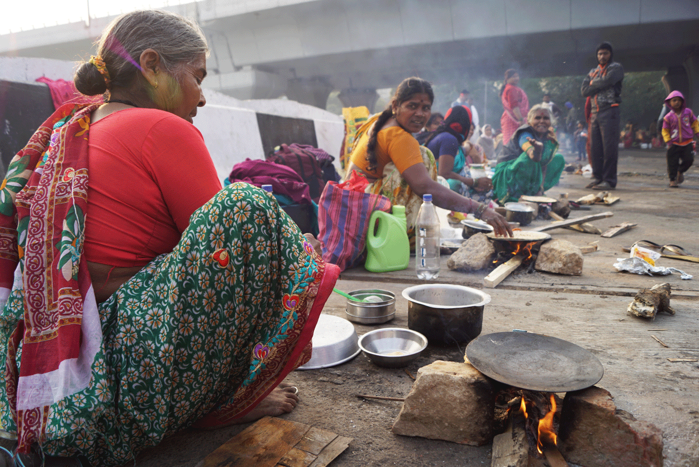 Women cook for their families on the side of the road
