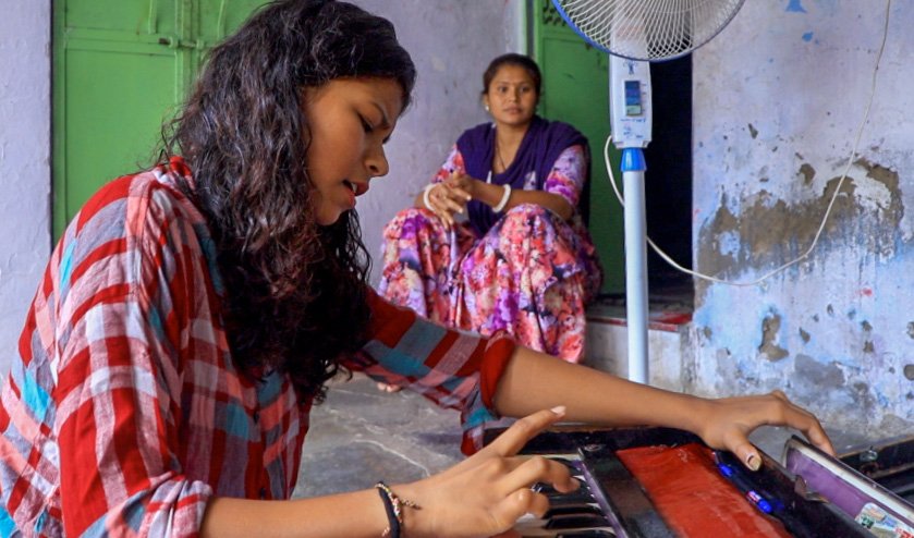 A girl is playing harmonium