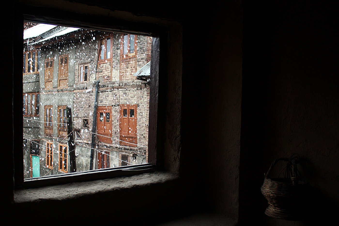 A kangri made in Charar-i-Sharief hanging on a wall on a snowy day in an old mud house in downtown Srinagar