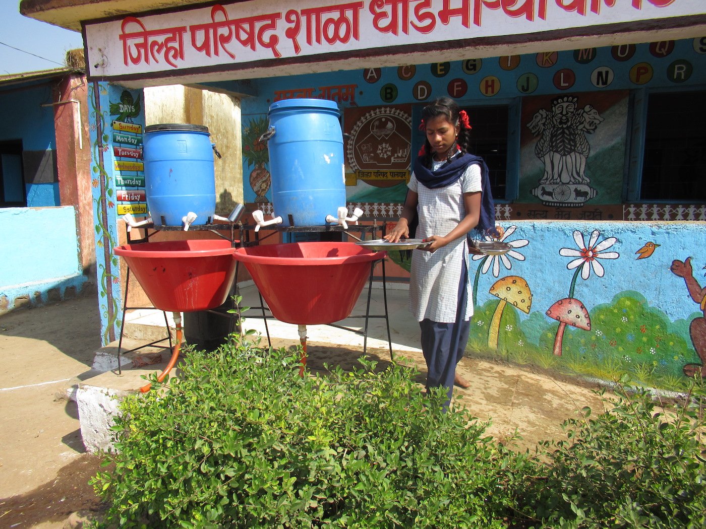 The students at the Dhondmaryachimet ZP school wash their plates before eating their mid-day meal of rice and dal