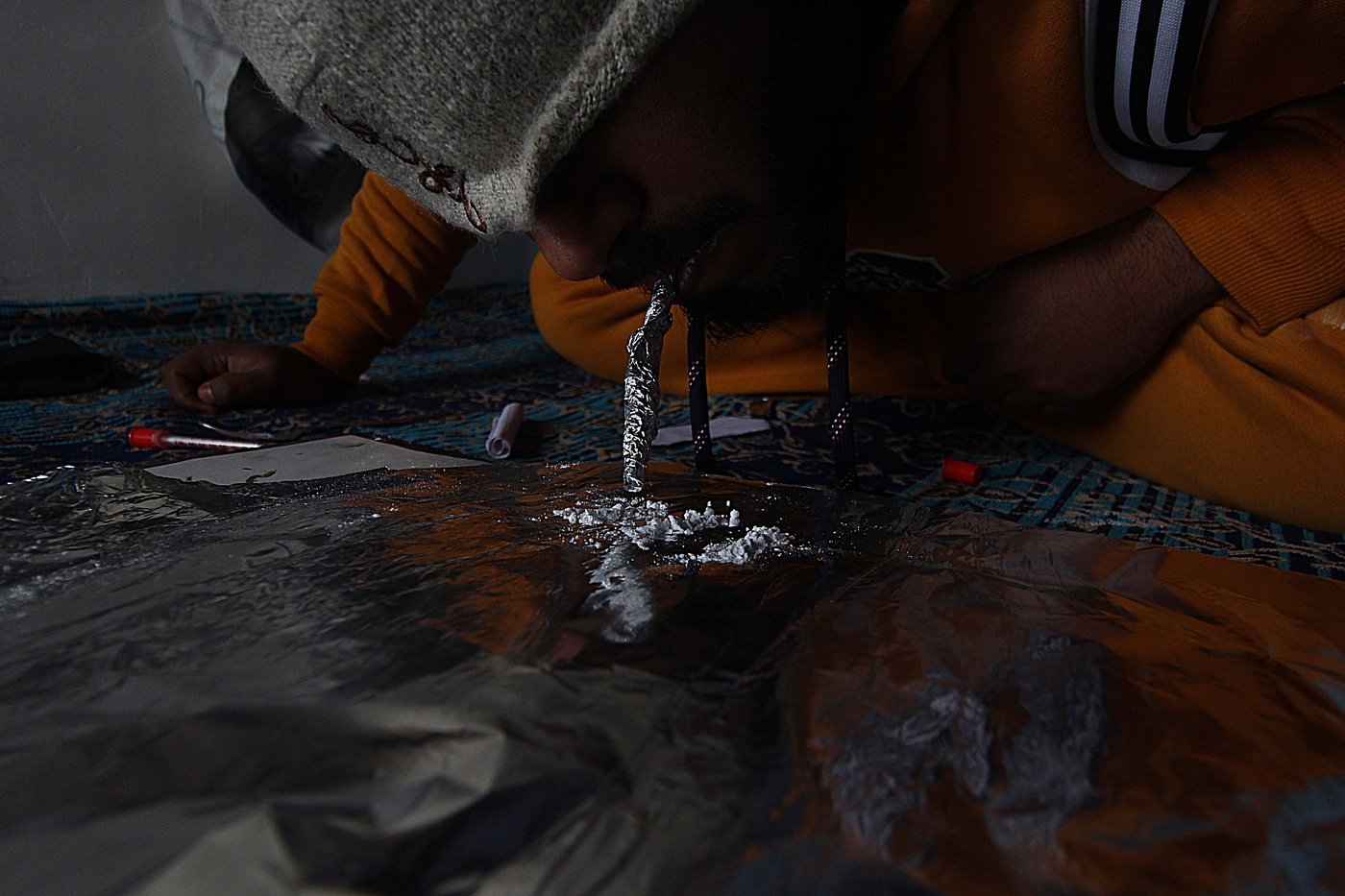 Right: In Budgam, a young man ingesting heroin